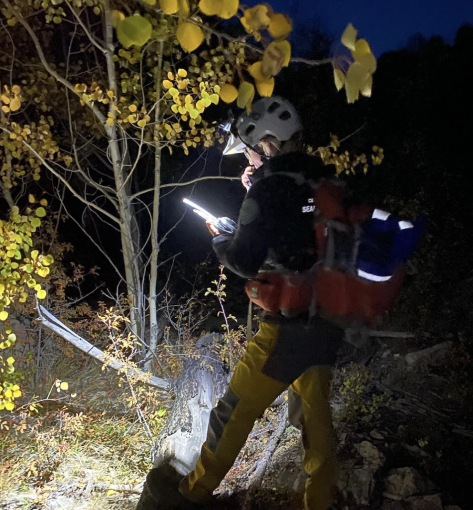 Search and Rescue Volunteer looking at a GPS at night